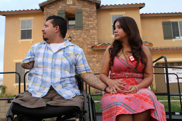 Juan Dominguez and his wife, Alexis, hold hands during the unveiling of a “smart home” donated to him and his family, Sept. 11, 2012. (U.S. Marine Corps/Jacob H. Harrer)