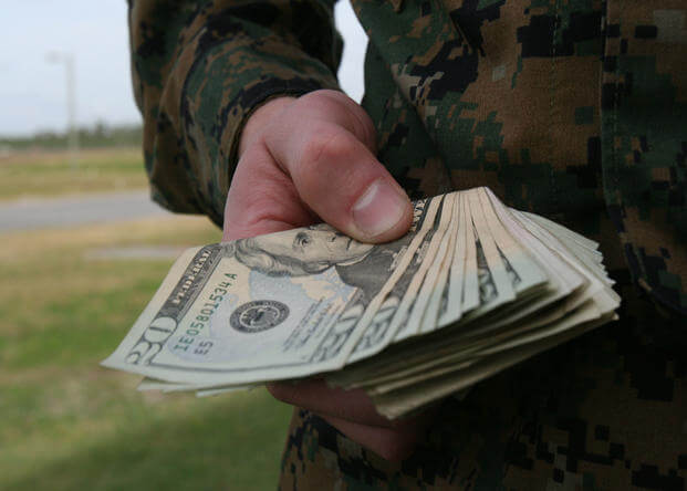 A hand holding a wad of cash. (U.S. Marine Corps photo by Sgt. Alicia R. Leaders)