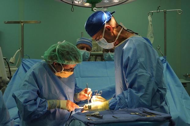 FILE PHOTO – Two doctors perform a procedure on a patient (Image: Health.mil)