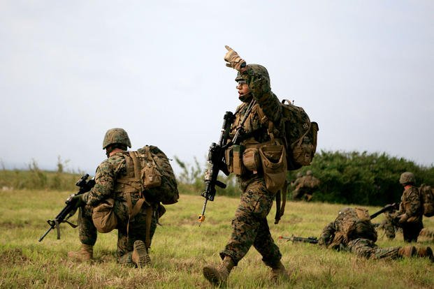 Cpl. Nicholas Escobedo, a squad leader with 2nd Squad, 1st Platoon, Echo Company (Co. E), Battalion Landing Team 2nd Battalion, 7th Marines (BLT 2/7), 31st Marine Expeditionary Unit (MEU), signals Marines to move forward during an airfield seizure exercise, April 7, 2010. (U.S. Marine Corps photo)