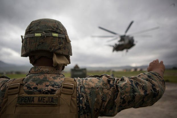 U.S. Marine Corps Lance Cpl. Brandon Penamejia, landing support specialist, Special Purpose Marine Air-Ground Task Force-Southern Command guides a CH-53E Super Stallion on Soto Cano Air Base, Honduras, July 10, 2015. (U.S. Marine Corps photo/Abraham Lopez)