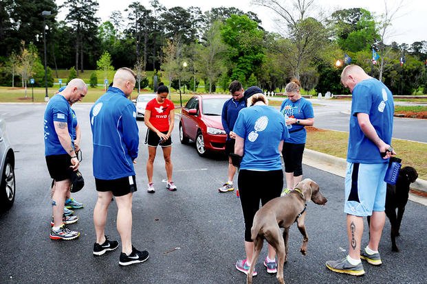 April 2015: Members of "wear blue: run to remember" gather with others in the Circle of Remembrance at the National Infantry Museum, as they say the names of service members who they are running for: Cpl. Matthew Commons, Staff Sgt. Michael Lammerts, Spc. Michael Demarsico, Staff Sgt. Edward Reynolds, Capt. Nicolas Rozanski, Sgt. Timmothy Owens, Staff Sgt. Keith Bishop, Staff Sgt. Tommy McFall and Staff Sgt. Robert Love. (US Army photo/Brittany Smith)