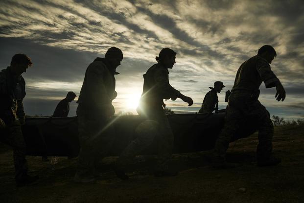 U.S. Army Green Berets carry a zodiac boat uphill prior to executing boat carries during a company team-building event on Oct. 30, 2018, Fort Carson, Colorado. (U.S. Army/Sgt. Connor Mendez)
