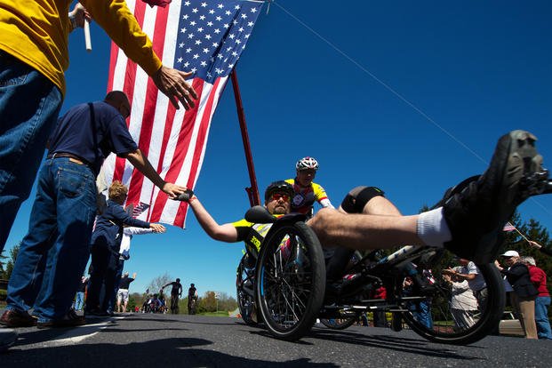 Navy veteran Petty Officer 1st Class Jay Somers gives high fives as he passes through a cheering crowd along the Face of America bike route in Gettysburg, Pa. April 24, 2016. (DoD/EJ Hersom)