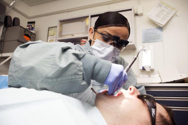 A hygienist performs a cleaning aboard the USS Abraham. (U.S. Navy/Laura Blanco)