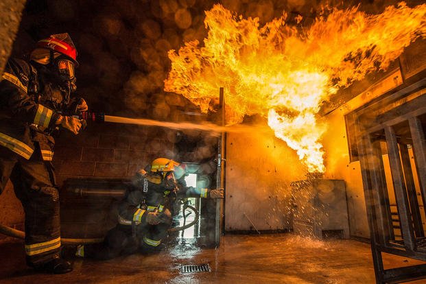 Air Force Chief Master Sgt. Eugene Elking extinguishes a fire while training with firefighters at Royal Air Force Molesworth, England, April 23, 2018. (U.S. Air Force photo by Tech. Sgt. Brian Kimball)