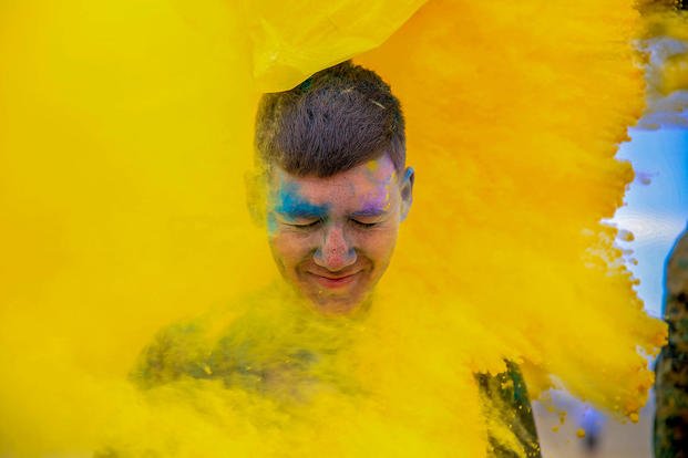 Yellow powder engulfs a Marine participating in the Color Consent Run for sexual assault prevention and awareness at Marine Corps Air Ground Combat Center Twentynine Palms, Calif., April 6, 2018. (U.S. Marine Corps photo by Cpl. Christian Lopez)