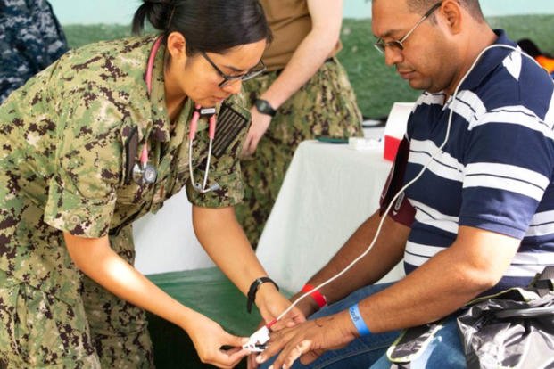 Ensign Kimberly Hill, left, takes the vital signs of a patient during a medical screening provided by the Navy hospital ship USNS Comfort. (US Navy photo/Winterlyn Patterson)