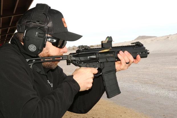 Sig Sauer’s Patrick Hanley firing Sig’s new newest version of the Rattler chambered in 5.56mm. (Military.com/Matthew Cox)