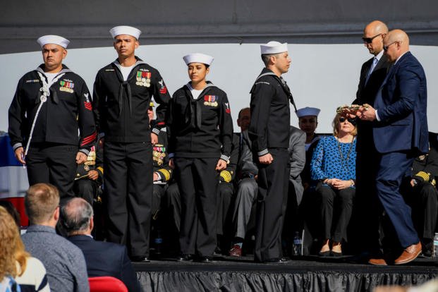  James and Joseph Monsoor, brothers of Michael Monsoor, pass the long glass to the first watch during the Jan. 26 commissioning ceremony of USS Michael Monsoor (DDG 1001). The warship is the second Zumwalt-class destroyer to enter the fleet, and is named for fallen Master-at-Arms 2nd Class (SEAL) Michael Monsoor, posthumously awarded the Medal of Honor for his heroic actions while serving in Ramadi, Iraq, in 2006. (US Navy photo/Alex Millar)