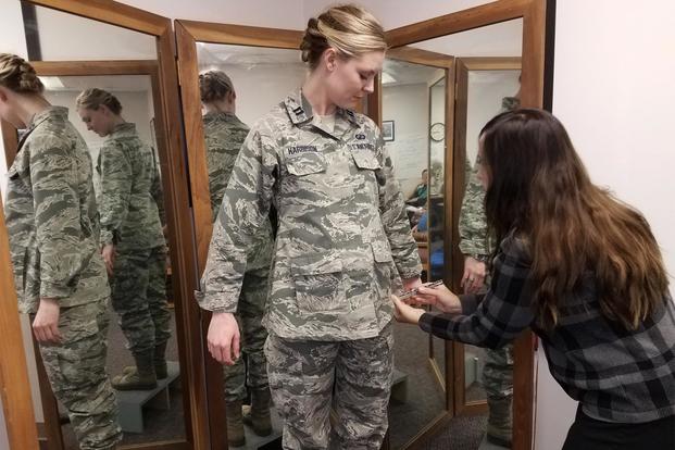 Stacey Butler (right) a clothing designer with the Air Force Life Cycle Management Center's Air Force Uniform Office, measures Capt. Taylor Harrison's maternity Airman Battle Uniform. ( U.S. Air Force/Brian Brackens)