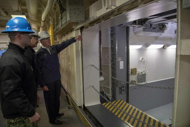  Navy Secretary Richard V. Spencer is briefed by Lt. Cmdr. Chabonnie Alexander, USS Gerald R. Ford’s (CVN 78) ordnance handling officer, on the Upper Stage 1 advanced weapons elevator during a tour of the Navy’s newest aircraft carrier on Jan. 17, 2018. (U.S. Navy photo by Mass Communication Specialist 2nd Class Kiana A. Raines) 
