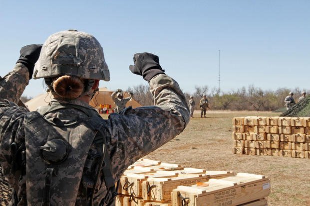 Pfc. Katherine Beatty gives helpful hints to her teammate holding four excess gunpowder bags that weren’t needed for the three-increment charge during live-fire training on the M119A3 howitzer, Fort Sill, Okla., March 1, 2016. Beatty is the Army’s first 13B cannon crewmember to graduate from advanced individual training, taught in 1st Battalion, 78th Field Artillery. (U.S. Army photo/Cindy McIntyre)