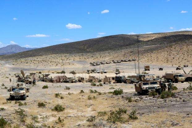 Vehicles and command tents of the 3rd Infantry Division’s 2nd Armored Brigade sit in a valley surrounded by mountainous terrain in an attempt to hide from the enemy during a recent rotation at the National Training Center at Fort Irwin, California. Matthew Cox/Military.com