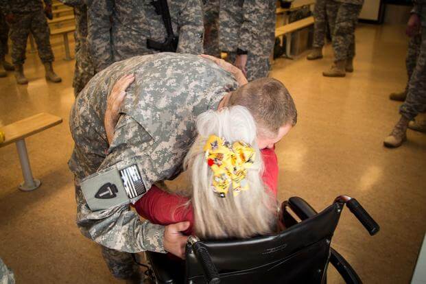 FILE -- A soldier from the 1-112th Cavalry Regiment, 72nd Infantry Brigade Combat Team, receives a hug from Elizabeth Laird before boarding a plane at Robert Gray Army Airfield on Sep. 13, 2015 in this file photo. Laird was commonly known as “The Hug Lady” at Fort Hood. (Randy Stillinger/U.S. Army)