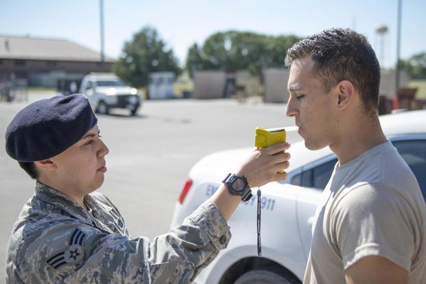 U.S. Air Force Senior Airman Rylynn Paz demonstrates the proper use of a portable breathalyzer test (PBT) with Airman 1st Class John Cabral at Whiteman Air Force Base, Mo., Sept. 30, 2016. (U.S. Air Force/1st Lt. Matthew Van Wagenen)