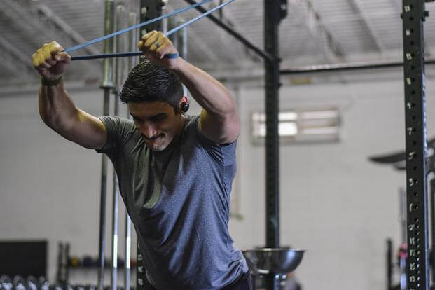 A pararescueman works out while using technologies that track his physical and mental well-being.