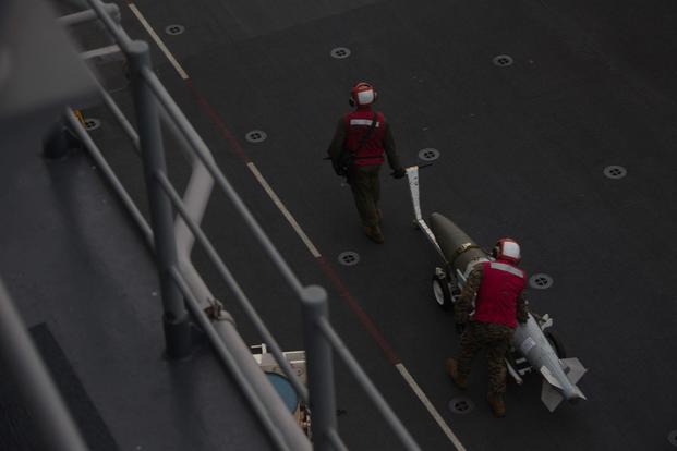 Marines move Joint Direct Attack Munitions and laser guided bombs during an aerial gunnery and ordnance hot-reloading exercise aboard the USS Wasp, Solomon Sea, August 4, 2019. (U.S. Marine Corps photo by Lance Cpl. Dylan Hess)