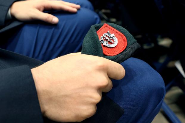A soldier from the U.S. Army John F. Kennedy Special Warfare Center and School, clutches his newly awarded green beret during a Regimental First Formation at the Crown Arena in Fayetteville, North Carolina, August 1, 2019. The ceremony marked the completion of four phases of the Special Forces Qualification Course where soldiers earned the honor of wearing the green beret, the official headgear of Special Forces. (K. Kassens/U.S. Army)