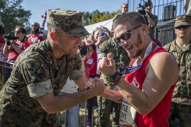  U.S. Marine Corps Col. Joseph Murray, left, commanding officer, Marine Corps Base Quantico, presents a finisher medal to retired Marine Cpl. Kyle Carpenter, a Medal of Honor recipient, after crossing the finish line of the 42nd Marine Corps Marathon in Arlington, Va., on Oct. 22, 2017. (U.S. Marine Corps photo by Lance Cpl. Yasmin D. Perez)