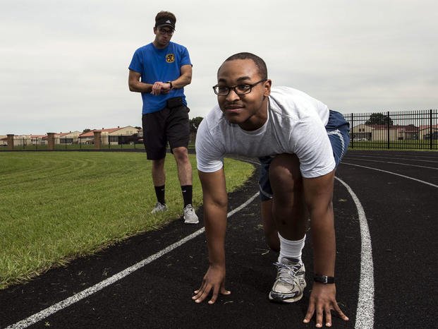 Josh Hale, 42nd Force Support Squadron personal trainer, starts his stop watch as Senior Airman Christopher Snowden, 42nd Command Post command and control operations specialist, trains for his physical training test. (U.S. Air Force/Alexa Culbert)