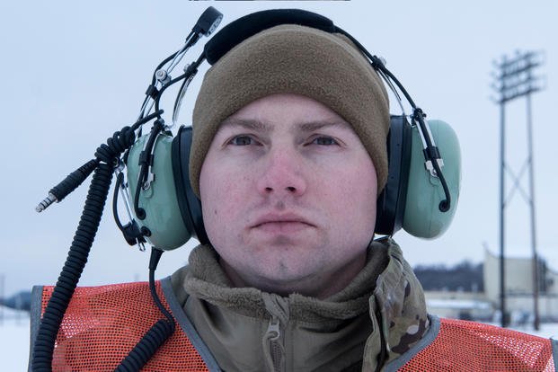 An airman wears a brown cap.