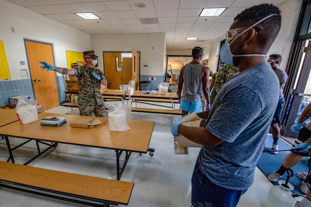 Sailors and Marines sterilize a building in support of USS Theodore Roosevelt