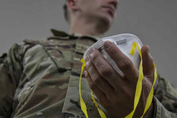 An Airman assigned to 407th Expeditionary Logistics Readiness Flight, adjusts the straps to his N95 mask.