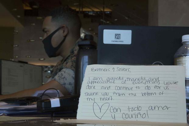 U.S. Marines display notes from quarantined sailors from the aircraft carrier USS Theodore Roosevelt. 