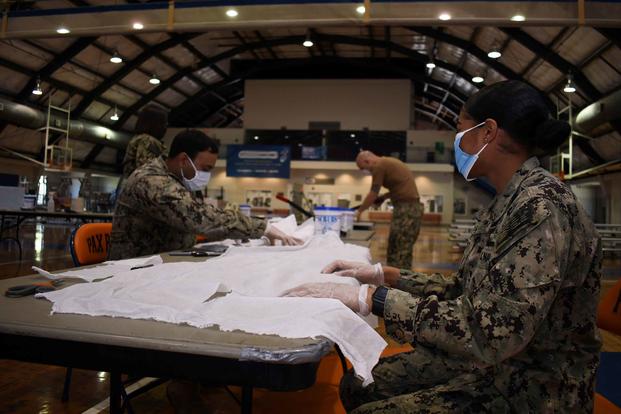Volunteers construct face masks for base personnel at the Patuxent River drill hall