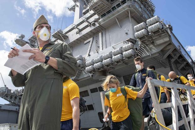 U.S. sailors assigned to the aircraft carrier Theodore Roosevelt ove to off-ship berthing.