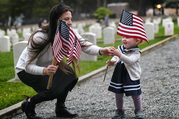 mother and toddler holding flags