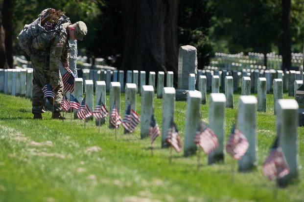 Soldiers participate in "Flags In" at Arlington National Cemetery in 2018.