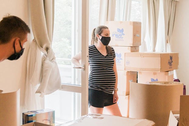 woman wearing mask in room of boxes
