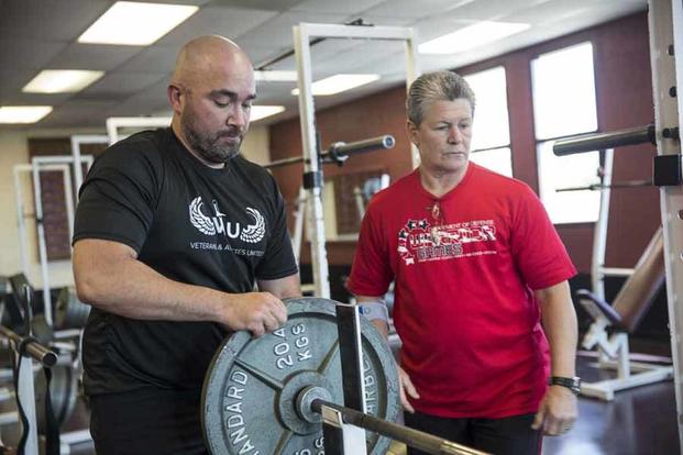  U.S. Marine Corps veteran Charles Dane adds weight to the bar during a Warrior Games powerlifting practice.