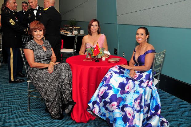 three women in ball gowns sitting at a table