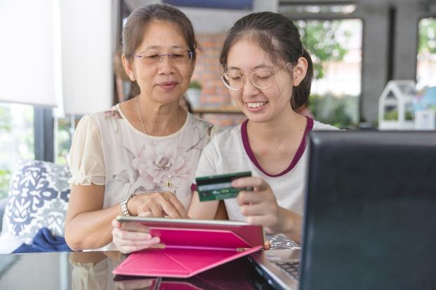 Parent teaching child how to use credit card