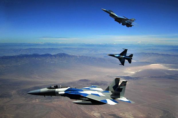 A U.S. Air Force F-15C and two F-16s from the 65th Aggressor Squadron break formation after a dogfight
