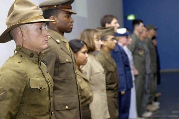 Airmen showing off historical uniforms in a lineup.