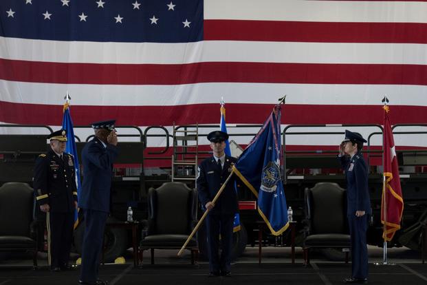 Gen. Jacqueline D. Van Ovost salutes Gen. Charles Q. Brown Jr. during a change of command ceremony.