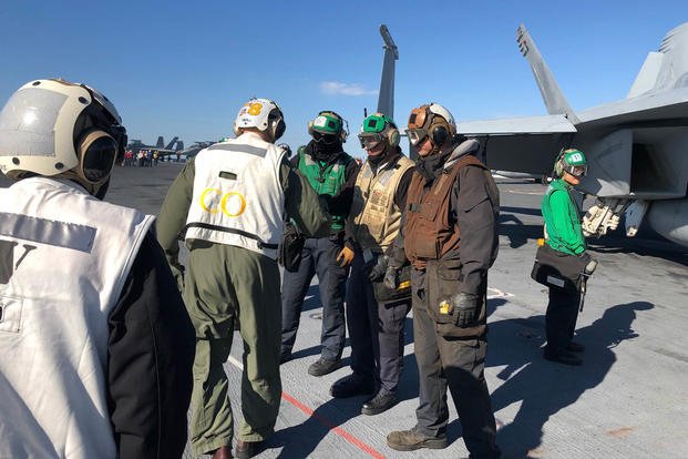 The commanding officer of the carrier Gerald R. Ford, Capt. J.J. "Yank" Cummings, greets crew on the Ford's flight deck Nov. 17, 2020 during an underway period off the coast of Norfolk, Va. (Hope Hodge Seck/Staff)