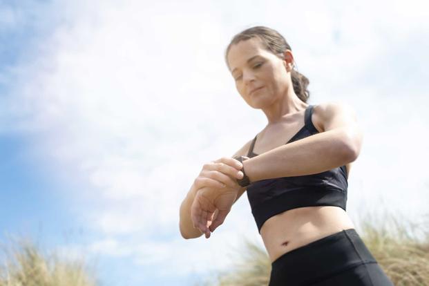 Woman checking fitness tracker whilst exercising