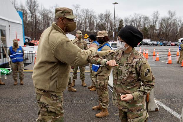 U.S. Army Sgt. Maj. Dwayne Swinton congratulates U.S. Army Pvt. Josselin Panameno.