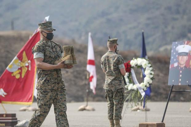U.S. Marine carries combat boots during a memorial service at Camp Pendleton.