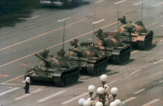 A man stands alone to block a line of tanks heading east on Beijing's Tiananmen Square. 