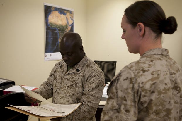 Gunnery sergeant, originally from Ghana, reviews award citations.