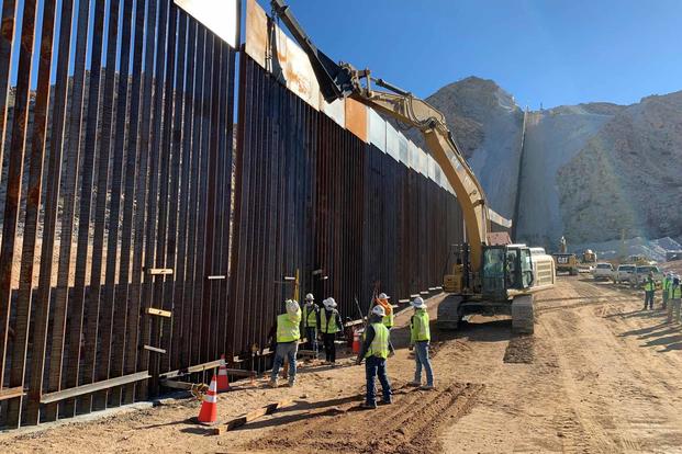 Army Corps of Engineers contractors install the final border wall panel near Yuma.