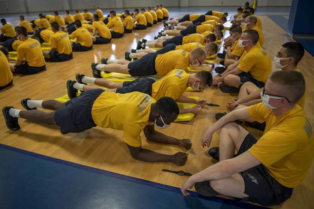 Navy recruits perform the forearm planks portion of their final physical fitness assessment.