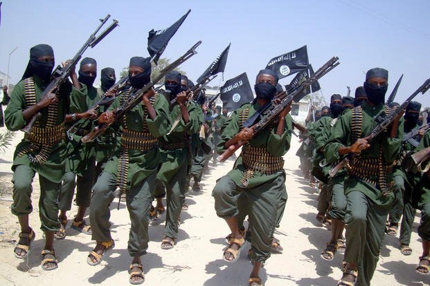 al-Shabab fighters march with their weapons during military exercises on the outskirts of Mogadishu, Somalia