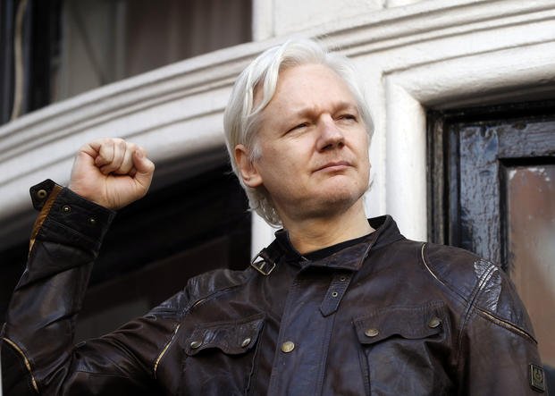 Julian Assange greets supporters outside the Ecuadorian embassy in London